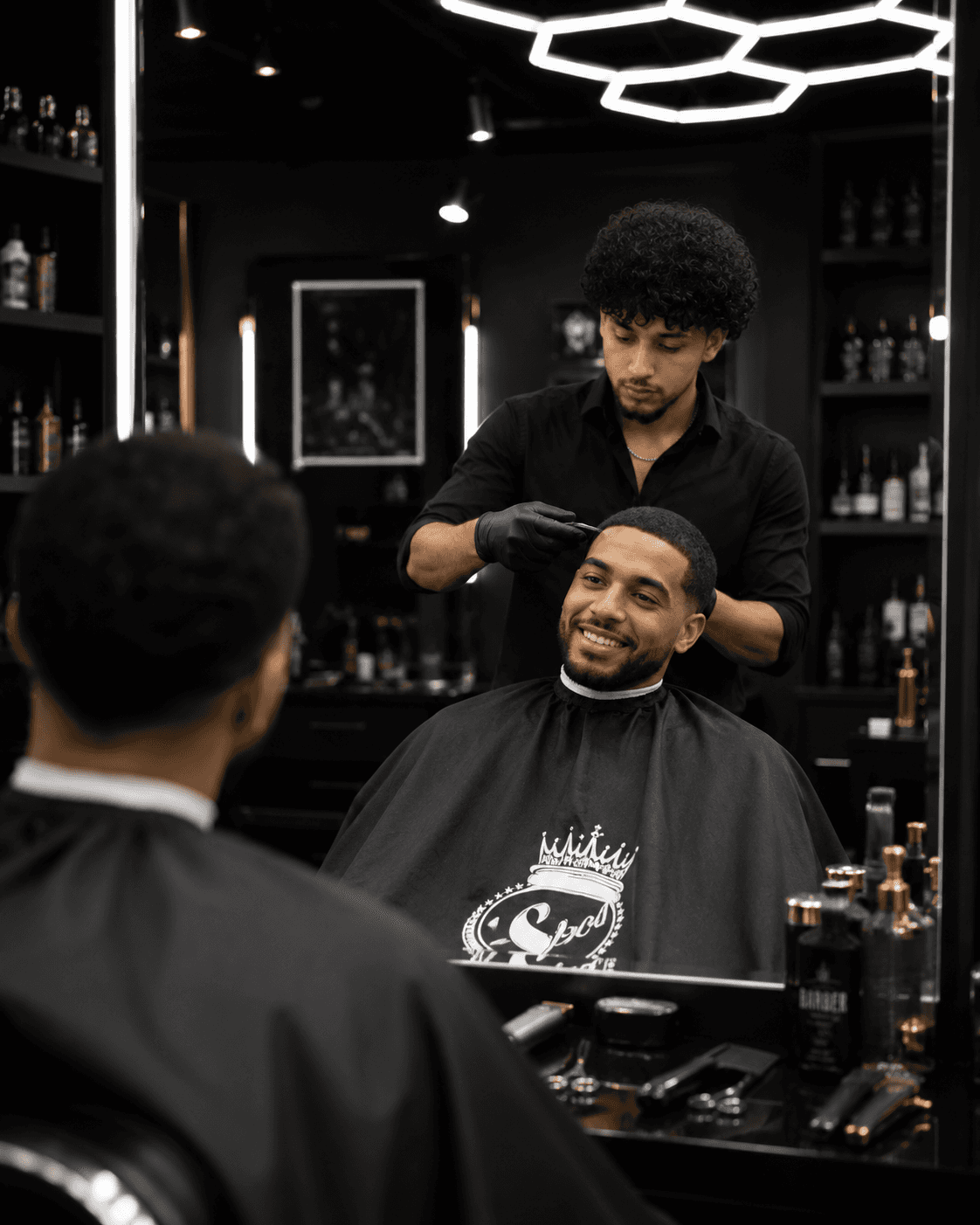 Barber shaping a client haircut beneath a ring light